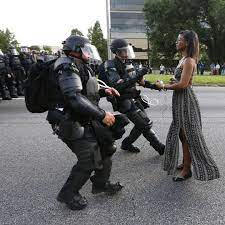 2016 BLM baton rouge-woman in dress stands ground versus riot police